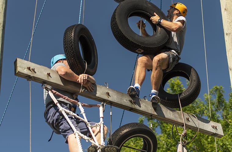 2 men climbing the rope & tire challenge