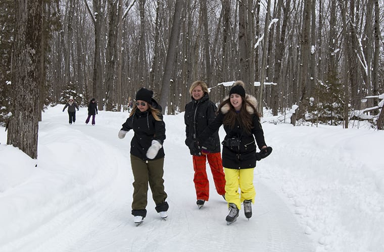group of women skating on the wooded trail
